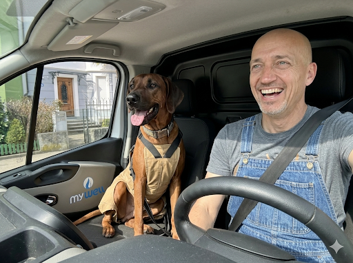 Gründer Rolf Meier mit Hund im MyWell Lieferwagen
